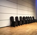 Black covered chairs against white wall on a modern wood stage