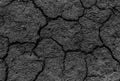 Black cracked surface of grey soil texture background, dark dried and chopped gray earth, old fissure dark ground, close-up, Royalty Free Stock Photo