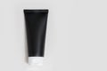 Black cream tubes on a light gray background. Cosmetic product for the care of the skin of the face, hands, feet and body Royalty Free Stock Photo