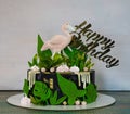 A black creamchease cake with flamingo and tropical leaves