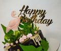 A black creamchease cake with flamingo and tropical leaves