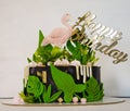 black creamchease cake with flamingo and tropical leaves