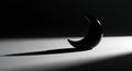 Black crescent object casts a dramatic long shadow Royalty Free Stock Photo