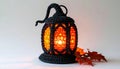 Black Crocheted Lantern Glowing Orange Light with Autumn Leaves on a White Background Studio Shot Royalty Free Stock Photo
