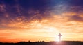 Black cross religion symbol silhouette in grass over sunset or sunrise sky Royalty Free Stock Photo