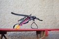 A black crossbow with a telescopic sight lies on a table in the yard. Preparing weapons for hunting