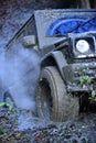 Black crossover driving with cloud of smoke through dirt. Royalty Free Stock Photo