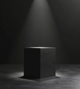 Black cube under spotlight on stage evoking mystery and simplicity Royalty Free Stock Photo