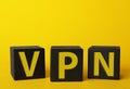 Black cubes with acronym VPN on yellow background, closeup view