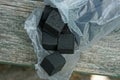 Black cubes of coal in an open plastic package Royalty Free Stock Photo