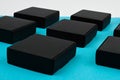 Black cubes side view. black boxes on blue. black boxes on a blue background on a flat lay. Black square on blue