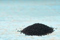 black cumin on a blue wooden table, selective focus