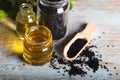 Black cumin oil with seeds on wooden background Royalty Free Stock Photo