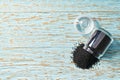 black cumin are poured from a glass jar on a blue wooden background, with copy space. Top view Royalty Free Stock Photo