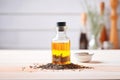 black cumin seed oil in a bottle with black seeds spilled around Royalty Free Stock Photo