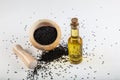 Black cumin seeds in bowl and essential oil in glass bottle. Nigella sativa isolated on white background Royalty Free Stock Photo