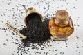 Black cumin seeds in bowl and essential oil in glass bottle. Nigella sativa isolated on white background Royalty Free Stock Photo