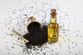 Black cumin seeds in bowl and essential oil in glass bottle. Nigella sativa isolated on white background Royalty Free Stock Photo