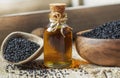 Black cumin seeds essential oil , Nigella Sativa in spoon on wooden background