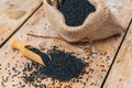 Black cumin seeds and wooden scoop, texture background Royalty Free Stock Photo