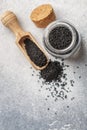 Black cumin seeds on a wooden spoon and in a glass jar Royalty Free Stock Photo