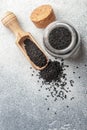 Black cumin seeds on a wooden spoon and in a glass jar Royalty Free Stock Photo