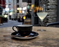 Black cup of cofee glass of wine table top at summer night street medieval city people relaxing in Tallinn Old town travel to Est Royalty Free Stock Photo