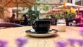 Black cup of coffee on wooden table in street cafe city urban life stile Rotermanni kvartal in Tallinn old town