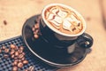 Black cup of freshly brewed espresso coffee. Close-up of coffee cup with milk and beans