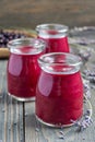 Black currant, greek yogurt, honey and lavender smoothie in glass with berries and flowers on background, vertical Royalty Free Stock Photo