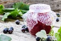 Black currant jam on the background of old boards near the green leaves and berries of currants. Natural currant jam Royalty Free Stock Photo