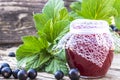 Black currant jam on the background of old boards near the green leaves and berries of currants. Natural currant jam Royalty Free Stock Photo