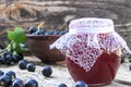 Black currant jam on the background of old boards near the green leaves and berries of currants. Natural currant jam Royalty Free Stock Photo