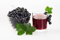 Black currant juice in a glass and ripe berries on a white background. Royalty Free Stock Photo