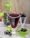 Black currant liquor and ripe berries on wooden