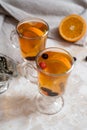 black currant tea with green leaves in a glass Cup in the autumn on the background of a window with raindrops on a white wooden Royalty Free Stock Photo