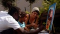 Black dad and caucasian mom with little baby daughter paint family portrait.