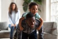 Black dad giving child piggyback ride carrying son on back Royalty Free Stock Photo