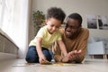 African father and little son collect jigsaw puzzle at home Royalty Free Stock Photo