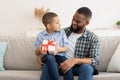 Black Daddy Congratulating Kid Son Giving Birthday Gift At Home