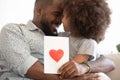 Black daddy hugging little daughter bonding holding greeting card