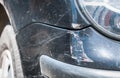 Black damaged car in crash accident with scratched paint and dented rear bumper metal body, close up selective focus Royalty Free Stock Photo