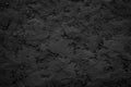 Black or dark gray rough grainy stone or sand plaster texture background