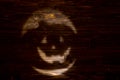 Black or dark laughing pumpkin Halloween Jack-o`-lantern of shadow on a dark wooden background. Jackolantern