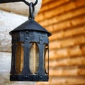 Black decorative antique forged metal lantern on an iron hook. A Royalty Free Stock Photo