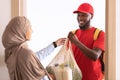 Black delivery guy giving net mesh bag with groceries