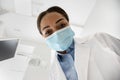 Black Dentist Lady Leaning Over Patient During Check Up In Dental Clinic