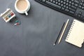 Black desk with coffee cup, keyboard, notebook,and pen placed in Royalty Free Stock Photo