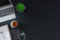 Black desktop with laptop, notebook with pen and other items. Top view with copy space, flat lay Royalty Free Stock Photo