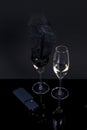 Black device and 2 glasses with champagne on a black background.